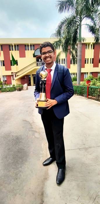 Vedant Agrawal holding a debate trophy